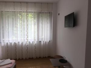 a living room with a window with white curtains at Paradox Oituz in Eforie Sud