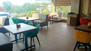 a restaurant with tables and chairs and a window at Hotel Amulya Royal Inn in Bangalore