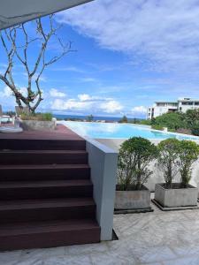a staircase leading to a swimming pool with trees at Blue Sky Condo by Palmetto Karon in Ka Rorn