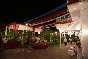a group of people walking outside of a building at night at royal palace and resort in Sultānpur