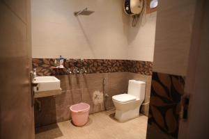 a small bathroom with a toilet and a sink at royal palace and resort in Sultānpur +36 photos