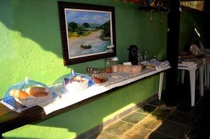 a table with baskets of food on a green wall at Pousada Em Busca do Sol in Trindade +46 photos