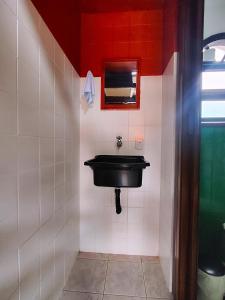 a bathroom with a black sink and a mirror at Pousada Em Busca do Sol in Trindade