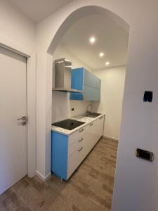 a kitchen with blue and white cabinets and a sink at Teodolinda in Trezzo sullʼAdda