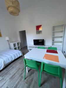 a room with a bed and a table with green chairs at Teodolinda in Trezzo sullʼAdda