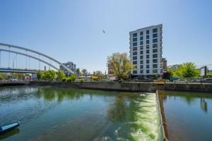 a river in a city with a bridge and buildings at Studio București in Bucharest