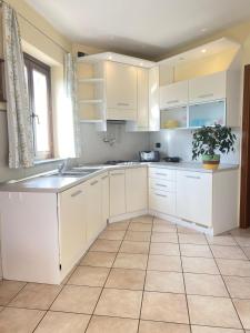 a kitchen with white cabinets and a potted plant at VerdeLago casa vacanze in Luino