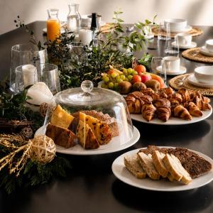 a table topped with three plates of bread and pastries at Casa Mare e Macchia in Propriano +13 photos