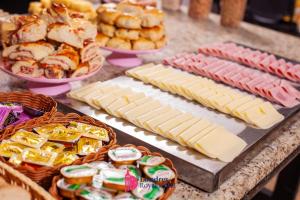 a table with cheese and other foods on it at Londres Royal Hotel in Londrina