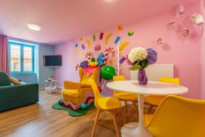 a living room with a table and yellow chairs at Le Candy by Clem in Pélussin