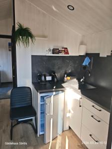 a small kitchen with a black counter and a chair at Gästehaus "Säntis" in Carnikava +34 photos