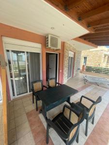 a patio with a table and chairs on a porch at Theodora villas Portaria beach 2 in Paralia Dionysiou