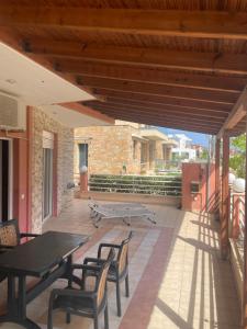 a patio with a table and chairs and a bench at Theodora villas Portaria beach 2 in Paralia Dionysiou +14 photos