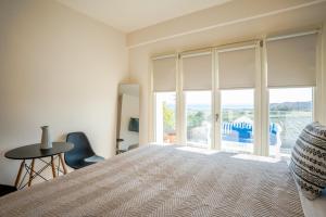 a bedroom with a bed and a large window at Apeiron Akrotiri - Apeiron Hotels in Akrotiri
