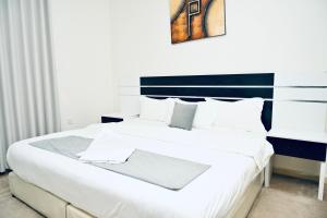 a bedroom with a large white bed with a blue headboard at روعة نجد القدس in Riyadh +97 photos
