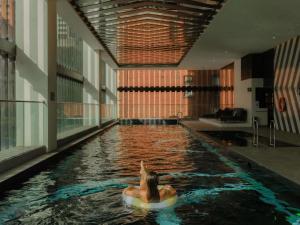 a woman in a raft in a pool in a building at Movenpick Hotel Melbourne On Spencer in Melbourne