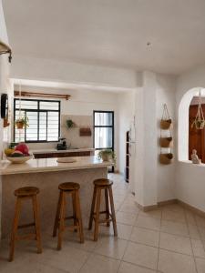 a kitchen with a counter and stools in it at Casa Cultivo in Brisas de Zicatela