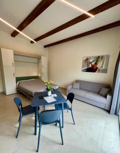 a room with a table and a bed and a couch at Fermata Sessant in Asti