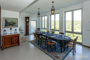 a dining room with a table and some windows at Le Château d'Aiguèze in Aiguèze