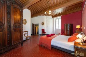a bedroom with a large bed with red pillows on it at Le Château d'Aiguèze in Aiguèze +170 photos