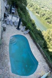 an overhead view of a swimming pool with chairs and a river at Le Château d'Aiguèze in Aiguèze