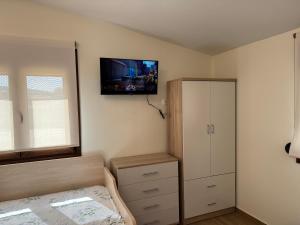 a bedroom with a bed and a tv on the wall at Artion Studios in Vourvourou