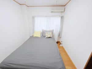 a bed in a small room with a window at LUMI HOUSE 101, 8 minutes to Namba 4 minutes walk to the station self check in in Osaka