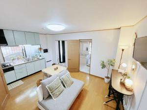 a living room with a couch and a table at LUMI HOUSE 101, 8 minutes to Namba 4 minutes walk to the station self check in in Osaka