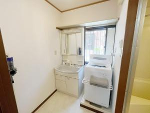a small bathroom with a sink and a washer at LUMI HOUSE 101, 8 minutes to Namba 4 minutes walk to the station self check in in Osaka +16 photos