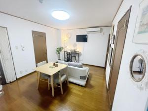 a living room with a table and a couch at LUMI HOUSE 101, 8 minutes to Namba 4 minutes walk to the station self check in in Osaka
