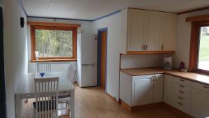 a kitchen with a table and a white refrigerator at Two bedroom Apartment 80m2 2nd floor in Bagn