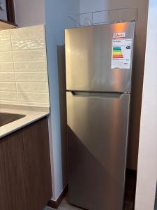 a stainless steel refrigerator in a kitchen next to a counter at Nova Studio Dpto nuevo a pasos de Av Alemania in Temuco
