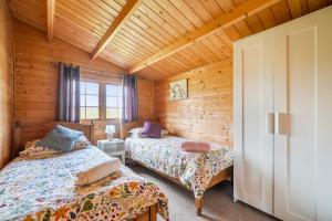 a bedroom with two beds in a wooden cabin at Moor View Cabin (Oak Tree Lane) in Okehampton