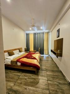 a bedroom with a large bed and a television at Hotal DESPRADES MRITYUNJAY INN in Jageshwar