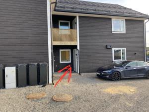 a black car parked in front of a house at GHAR-New 2 bedrooms apartment near airport and Oslo city-free parking in Klofta