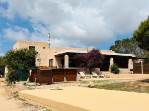 a house with chairs in front of it at Villa Turquoise Formentera in San Ferrán de ses Roques