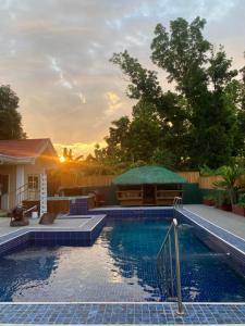 a swimming pool with a sunset in the background at Valdez & Ismail HOMESTAY in Apatot