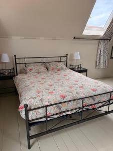 a bed with a floral comforter in a bedroom at het Binnenhuis in Workum