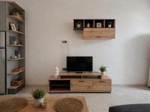 a living room with a television on a wooden entertainment center at Memories in Tinos