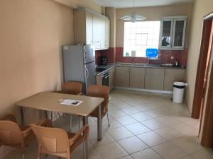 a kitchen with a table and chairs and a refrigerator at Theodora villas Portaria beach 2 in Paralia Dionysiou