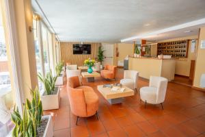 a lobby with chairs and tables in a building at Hotel Al Pescador in Lazise