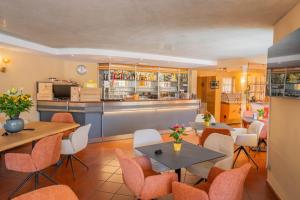 a restaurant with tables and chairs and a bar at Hotel Al Pescador in Lazise