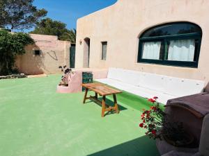 a patio with a white couch and a table at Villa Turquoise Formentera in San Ferrán de ses Roques