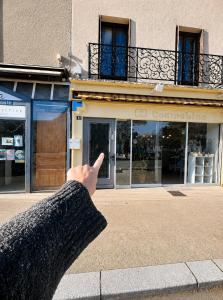 a person pointing at a building with their index finger at Le Candy by Clem in Pélussin