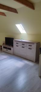 a living room with a tv and a large room with at Mirella apartman in Palić