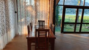 a dining room with a table and chairs and a window at Lakeside Echo Homestay in Kurunegala
