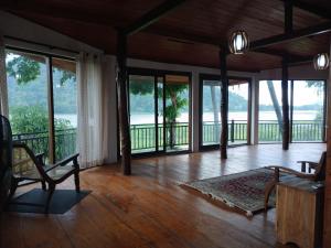 a living room with a table and chairs and windows at Lakeside Echo Homestay in Kurunegala