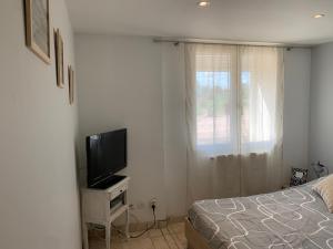 a bedroom with a bed and a flat screen tv at La Varenne in Changy