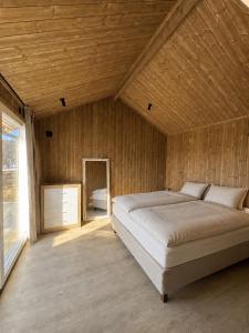 a bedroom with a large bed in a wooden wall at Jarfjord Nature Escape in Herjenes