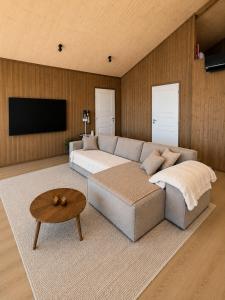 a living room with a couch and a flat screen tv at Jarfjord Nature Escape in Herjenes